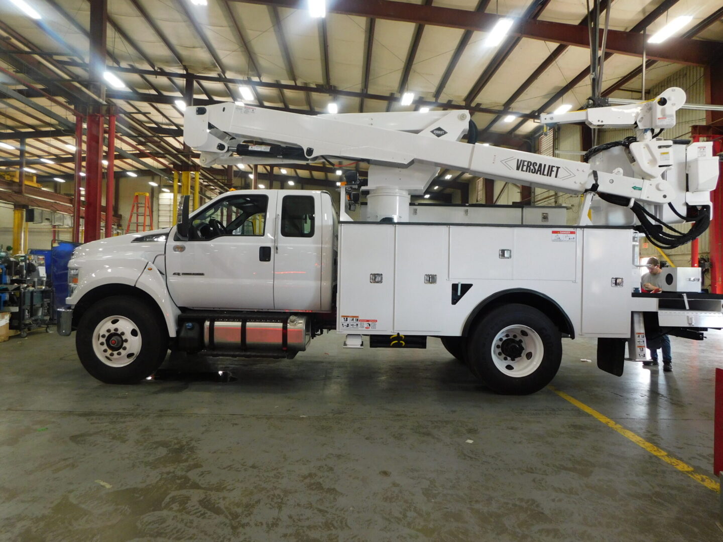 A white truck with a crane on the back of it.