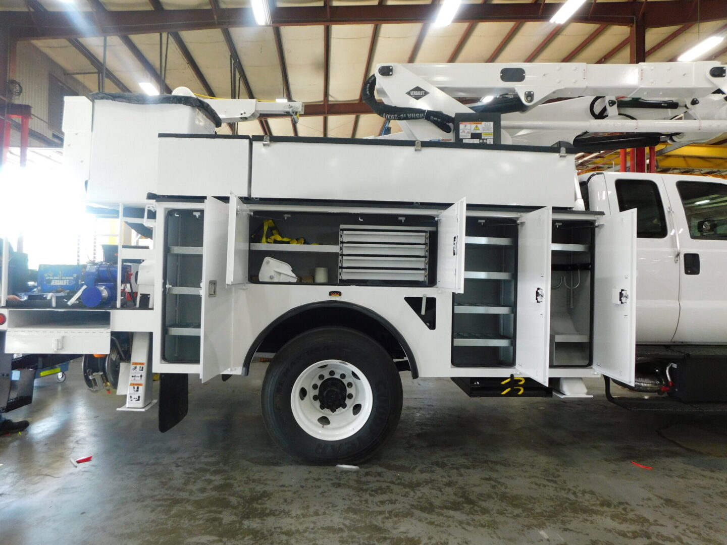 A white utility truck parked in a warehouse.