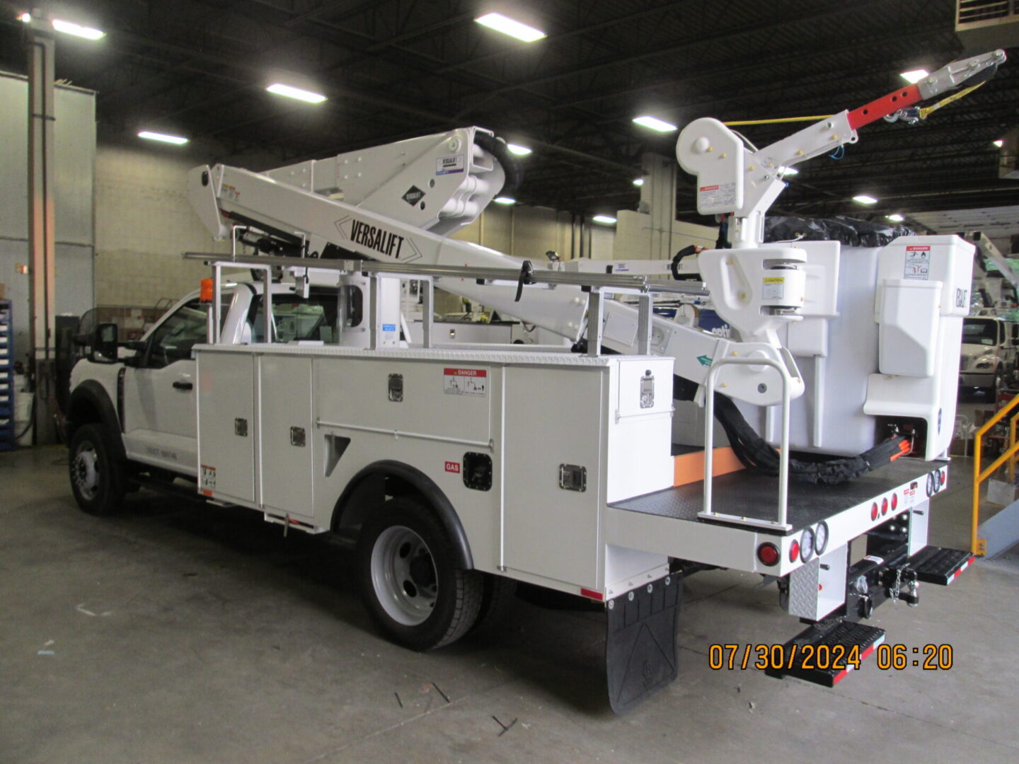 A white utility truck with a crane on the back.