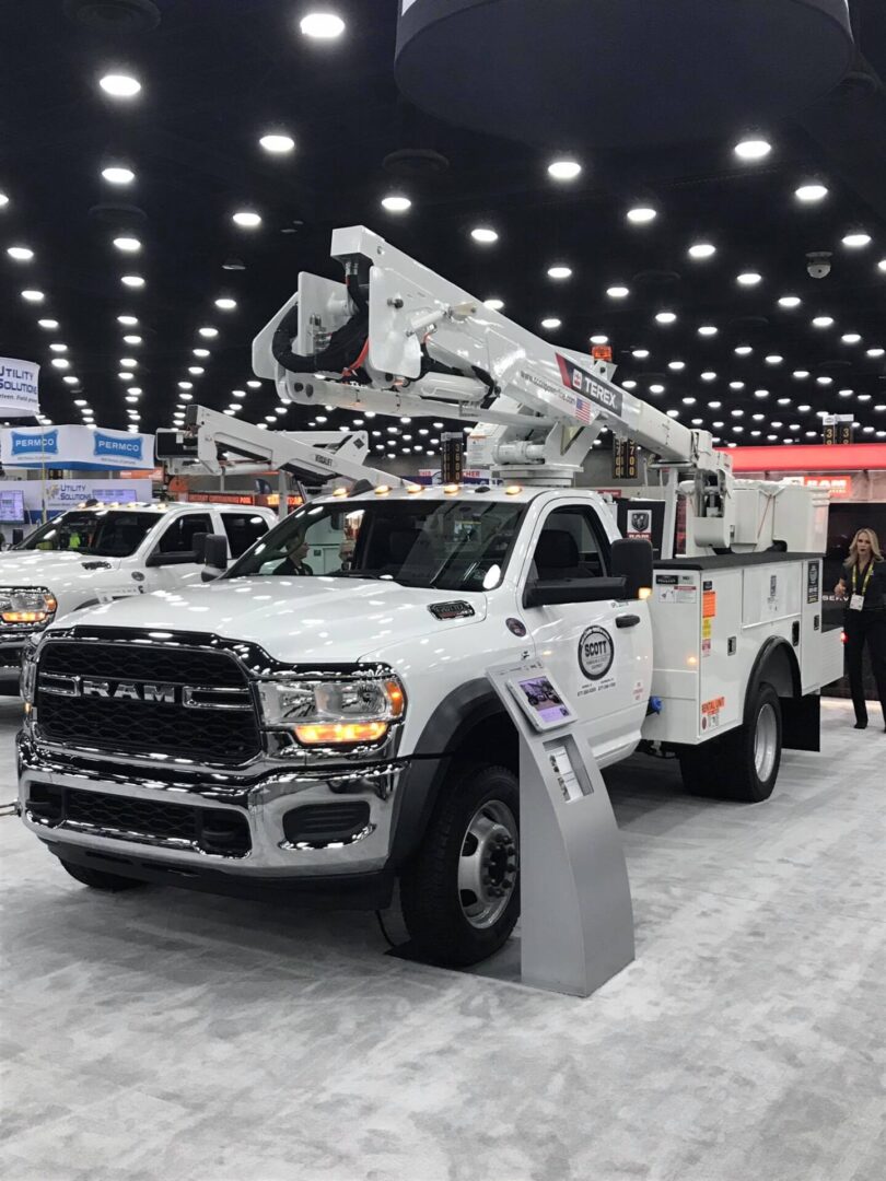 A white truck with a ladder on the back of it.