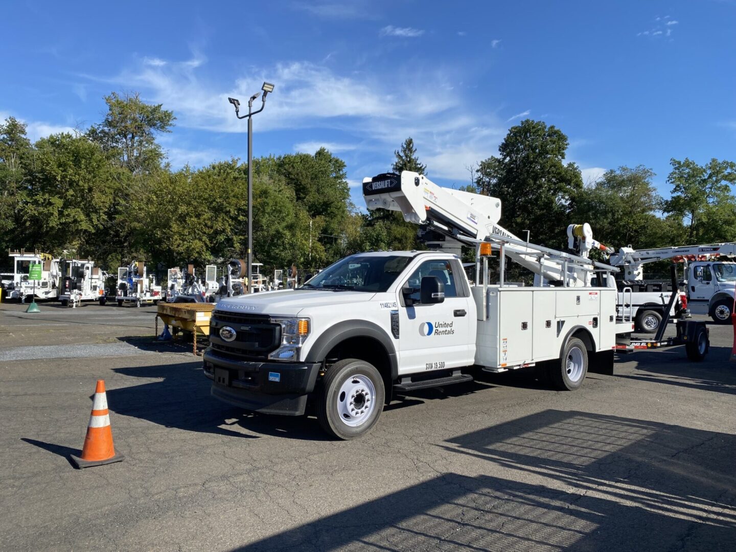 A white truck with a crane on the back of it.