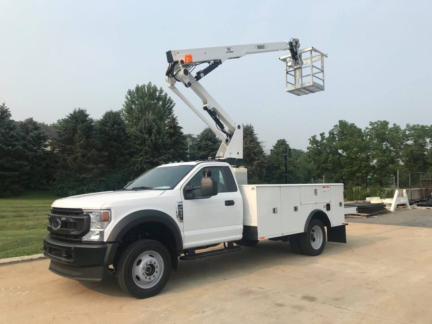 A white truck with a crane on the back of it.